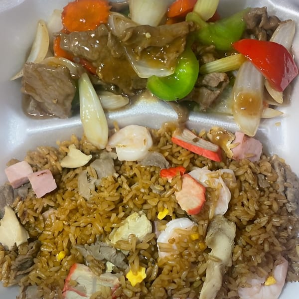 Beef and mixed vegetables with fried rice, shrimp, and ham in a takeout container.